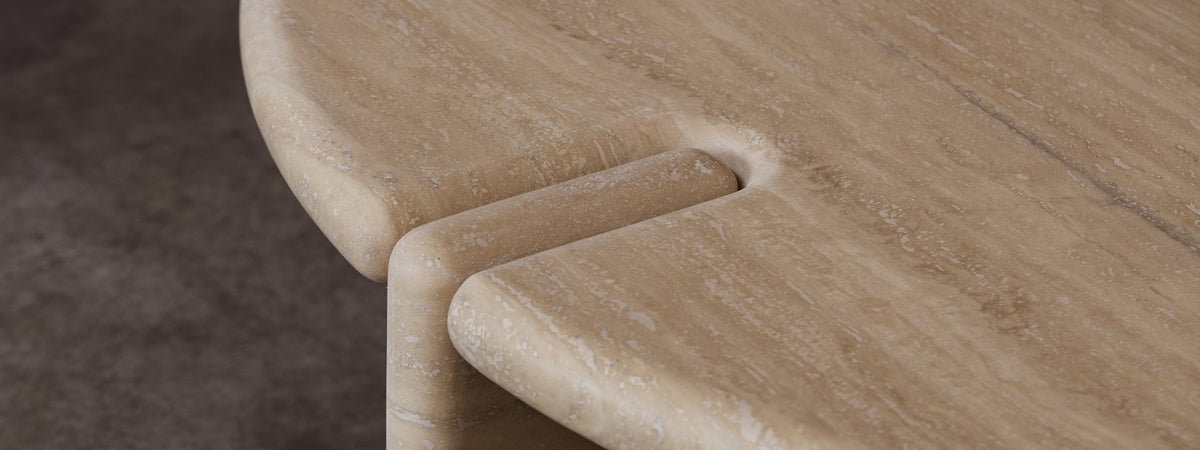 Close-up of a wooden chair with a curved design on a textured surface