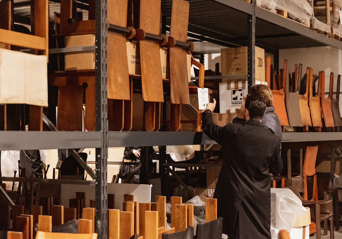 Person inspecting wooden panels on a rack in a warehouse setting