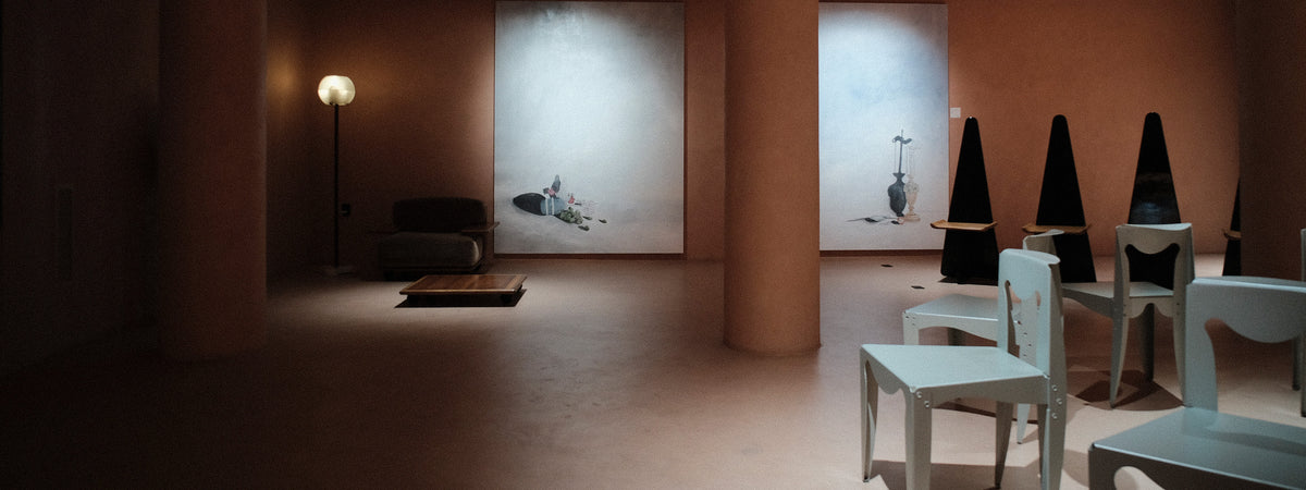 Modern interior design with white chairs, abstract art, and a floor lamp.