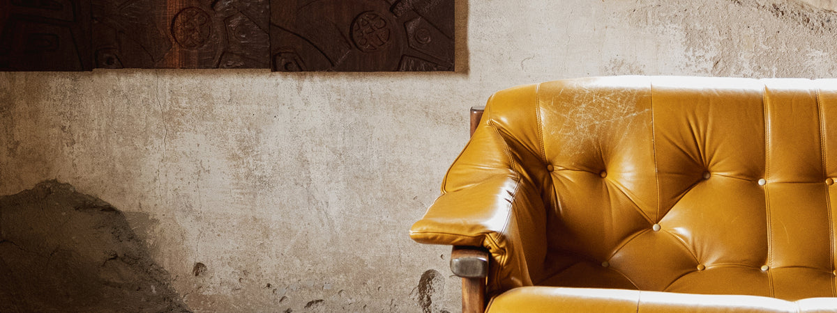 Yellow leather sofa against a textured wall.